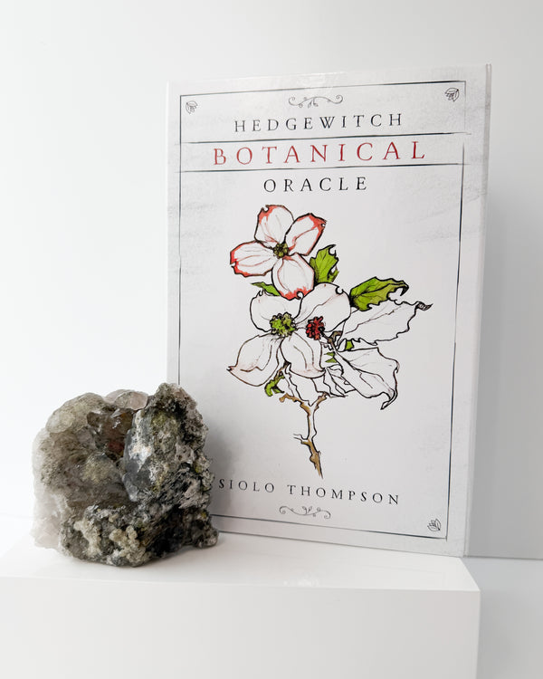 Botanical Oracle book with a garden quartz crystal on a white background