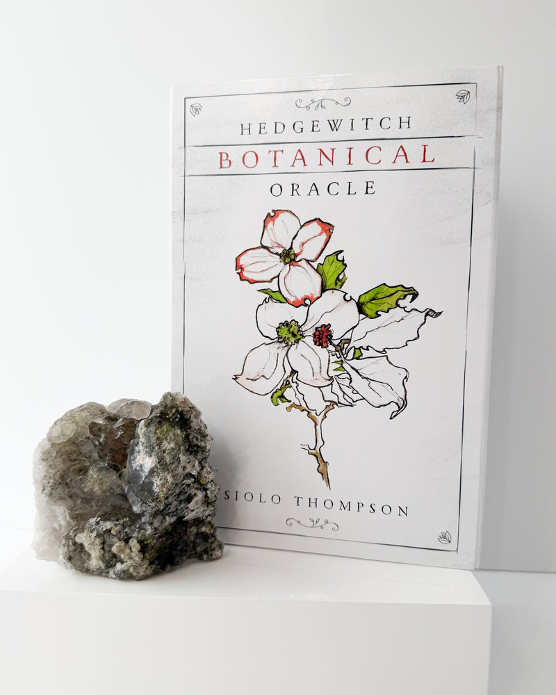 Botanical Oracle book with a garden quartz crystal on a white background