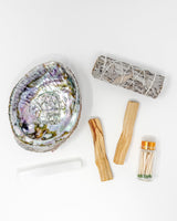 Abalone shell, matches, and wooden tools on a white background