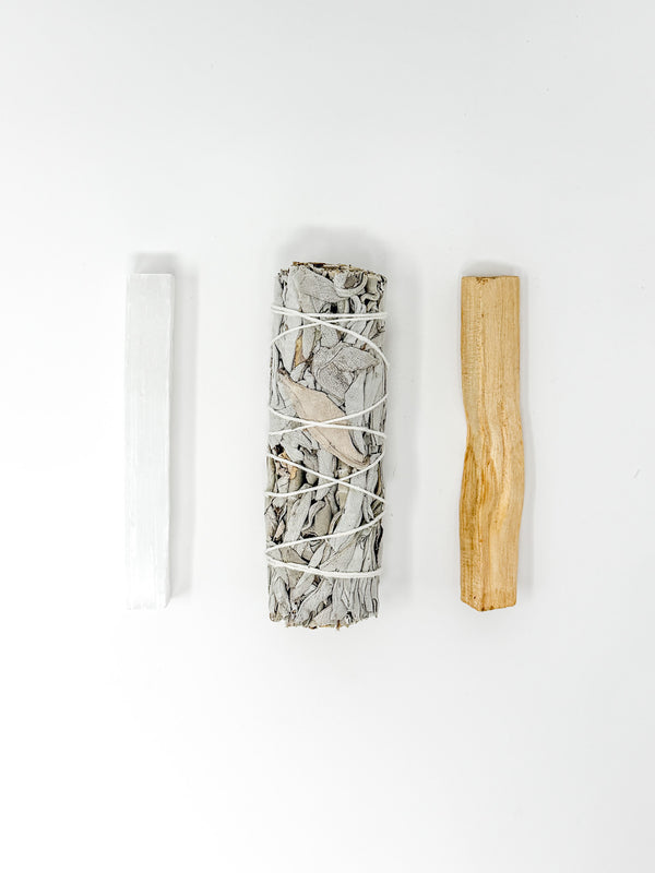 Three items on a white background: a cylindrical crystal bundle, a wooden stick, and a white tube.