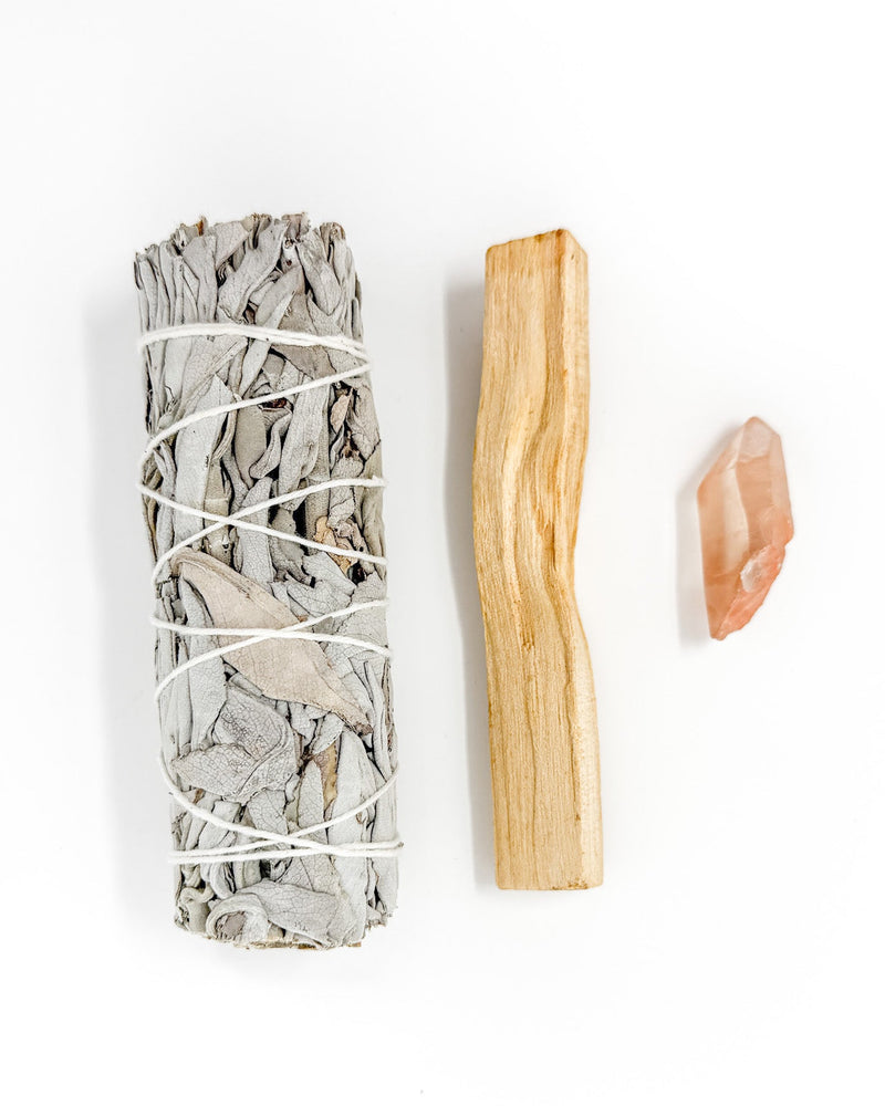 Sage bundle, Palo Santo stick, and Agate stone on a white background