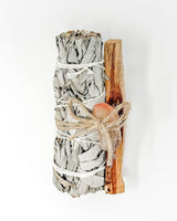 Smoldering sage bundle with wooden stick on a white background