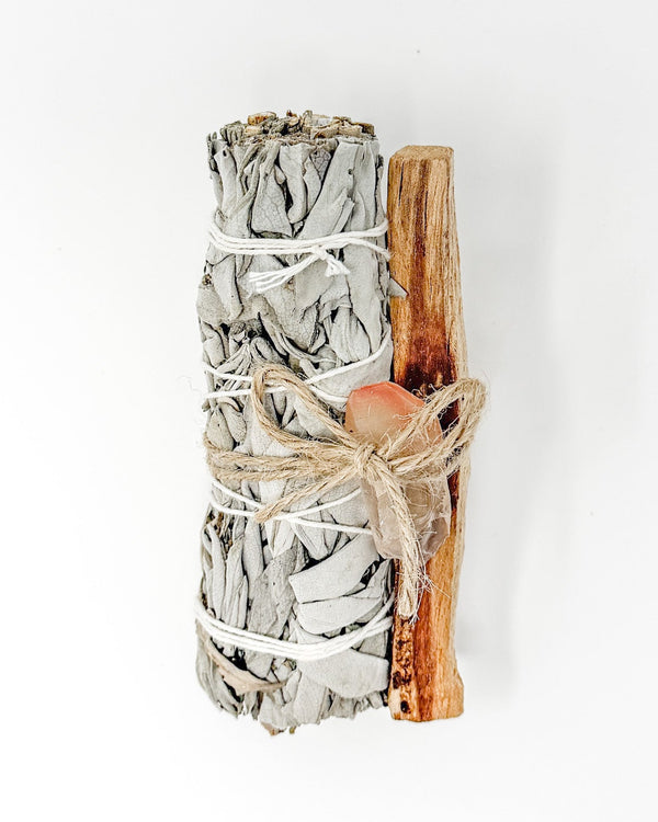 Smoldering sage bundle with wooden stick on a white background